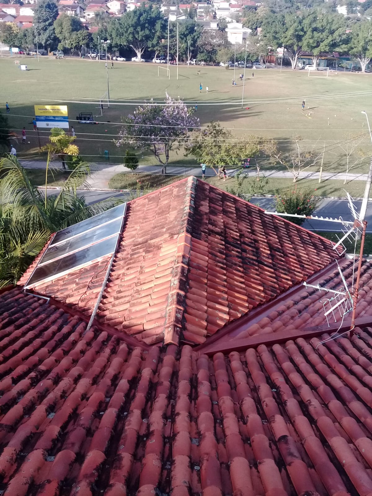 Telhado residencial com telhas de cerâmica visto de cima, mostrando o tipo de cobertura que a empresa limpa em São José dos Campos.